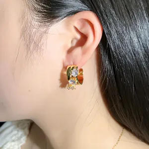 Chic gold C-shaped hoop earrings with sparkling rhinestones worn by a model