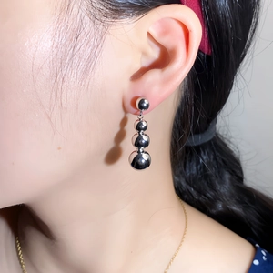 Polished silver sphere drop earrings with minimalist geometric design on model