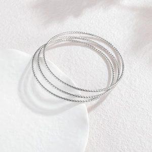 Détails de bagues en acier inoxydable argenté avec motifs diamantés sur socle blanc