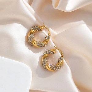 Créoles torsadées plaquées or 18 carats avec zircons micro-pavés sur fond de soie blanche