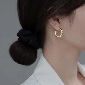 Polished 18K gold-plated chunky C-shape hoop earrings for women on a model