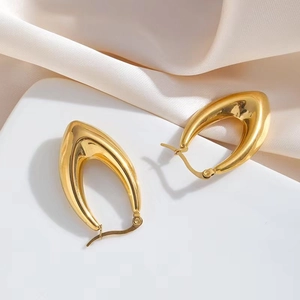 Close-up of 18k gold plated U-shaped teardrop earrings on champagne satin background