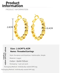 Détails rapprochés de boucles d'oreilles torsadées texturées plaquées or 18 carats