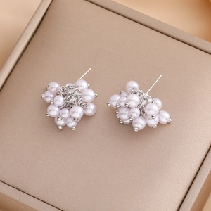 Elegant vintage pearl flower cluster stud earrings on leather jewelry box surface
