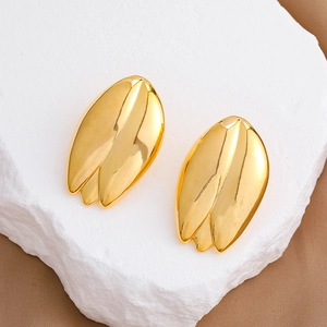 Boucles d'oreilles tulipes plaquées or 18 carats sur un support en pierre blanche épuré