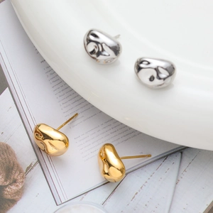 Minimalist gold and silver bean-shaped stud earrings with high-polish metallic finish