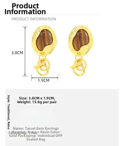 Detailed view of vintage gold brass earrings with resin tiger eye inlay and tassels
