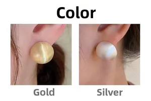Détail de boucles d'oreilles boules en métal brossé finitions or et argent mates