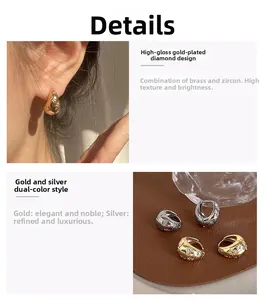 Detail of teardrop brass hoop earrings with zircon inlay in gold and silver finish
