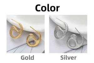 Detail view of gold and silver textured C-shape stud earrings with hammered finish