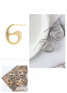 Macro shot of S925 silver needle snake-shaped earrings with hammered gold and silver finish