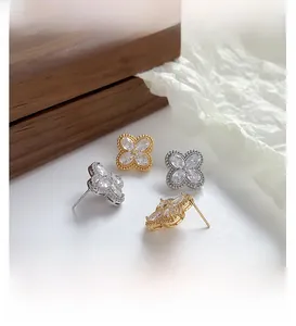 Macro detail of clover earrings with marquise zircons in gold and silver plating