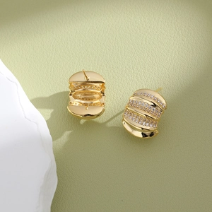 Elegant gold-plated C-shape stud earrings with zircon inlay on green leather background