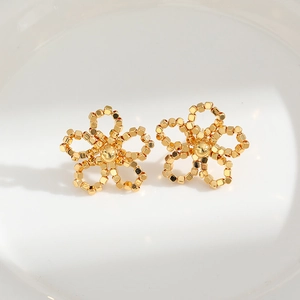 Boucles d'oreilles fleurs dorées élégantes sur porcelaine blanche et lumière douce