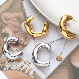 Modern twisted C-shape metal hoop earrings in gold and silver finish for women