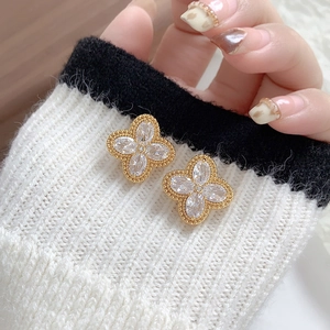 Elegant gold clover earrings with marquise-cut cubic zirconia on a knit sweater backdrop
