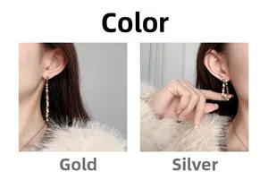 Detail view of gold tassel and silver ring drop earrings shown on model ear