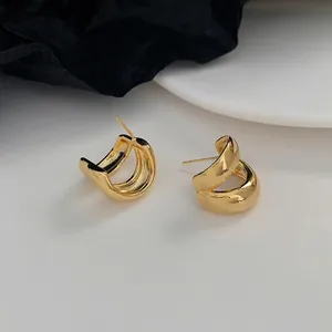 Minimalist double-layered gold curved earrings with a smooth polished metallic finish