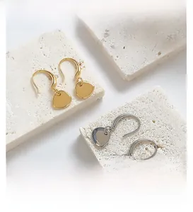 Detailed view of creative gold and silver hook earrings with geometric pendants