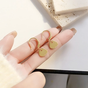 Detailed view of minimalist gold plated fishing hook earrings with irregular round discs