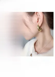 Detail of gold and silver teardrop earrings with micro-set cubic zirconia stones