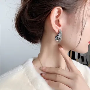 Chic silver teardrop earrings with sparkling cubic zirconia on elegant model