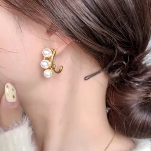 Orecchini a cerchio dorati con perle dal design geometrico minimalista ed elegante