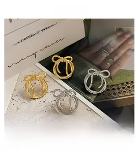 Detailed arrangement of gold and silver bow-shaped rings on a textured stone surface