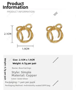 Detail view of gold bow earrings showing size 2.1cm by 1.9cm and copper material specs