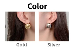 Detail of round geometric metal earrings in polished gold and silver finishes on ears