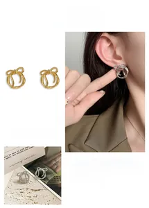 Detail of bow-shaped geometric hoop earrings in polished gold and silver finishes