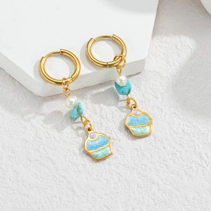 Gold hoop earrings with blue turquoise and cupcake charm in a beachy ceramic style