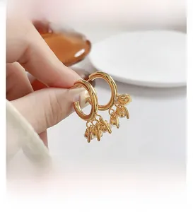 Détail de créoles plaquées or ornées de pendentifs scintillants en pierres de zircon
