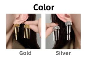 Detail of geometric tassel earrings in gold and silver with hammered metal texture