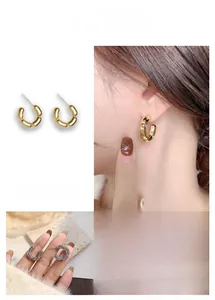 Détail de boucles d'oreilles segmentées en forme de C, finitions or et argent