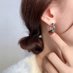 Créoles géométriques chic en argent au design segmenté portées par un mannequin femme