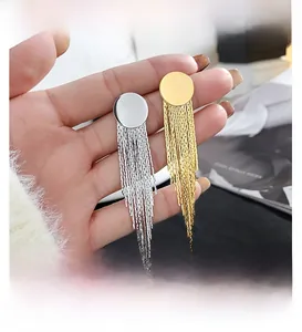Detailed close-up of long metal tassel earrings in gold and silver finish with chain fringe
