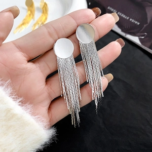 Detail of silver long tassel drop earrings held by hand showing flowing chain layers