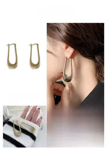Chic U-shaped metal earrings in gold and silver finish shown on model and flat lay