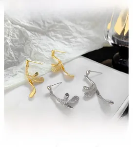 Detail view of 24K gold and silver leaf earrings with shimmering pavé zircon stones