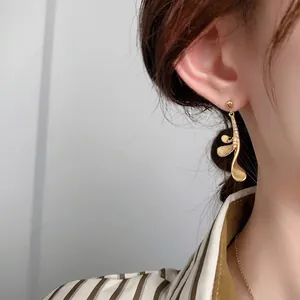 French luxury 24K gold plated music note earrings with zircons shown on model