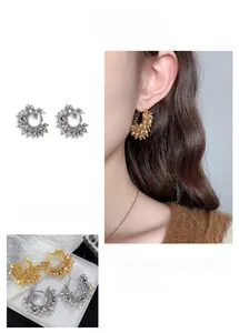 Detailed macro of C-shaped hoop earrings with textured gold and silver vintage finish
