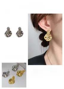 Detailed close-up of irregular textured lava style earrings with micro-inlaid stones