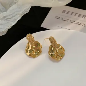 Chic irregular molten metal stud earrings with high-shine gold plating on display