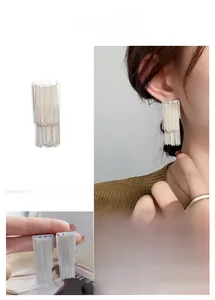 Detail view of silver multi-row chain tassel earrings showing draped metallic fringe style