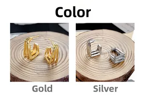 Détail de boucles d'oreilles créoles en C à trois couches en finitions or et argent polies