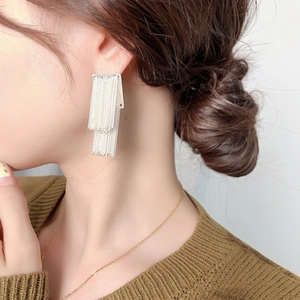 French vintage chain tassel earrings plated in 18k gold on model with neutral background