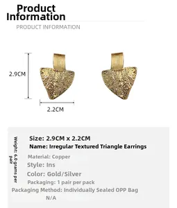 Detailed view of gold irregular triangle earrings with textured copper surface