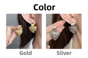 Detail of geometric triangle stud earrings in gold and silver with hammer texture finish