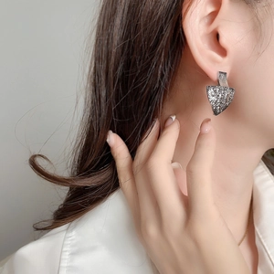 Irregular silver geometric earrings with lava texture on female model in a modern style